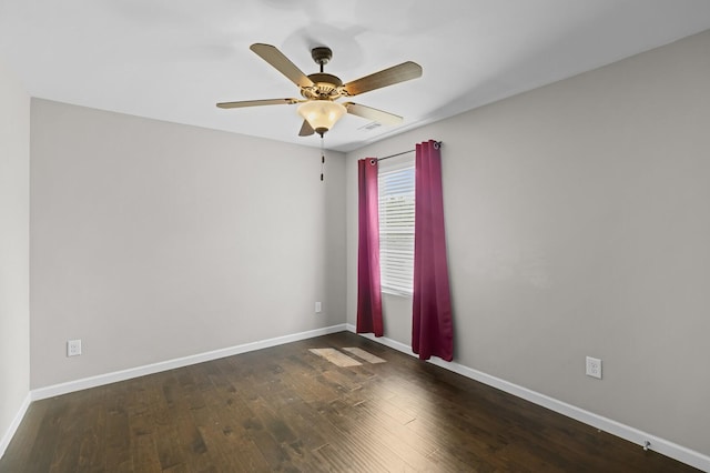 empty room featuring wood finished floors, baseboards, and a ceiling fan