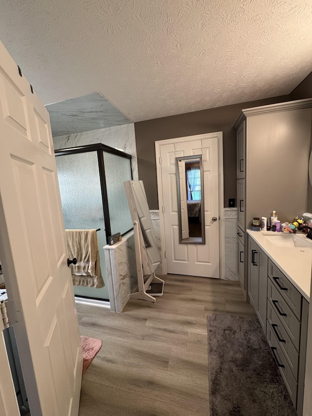 162 Pigeon Roost Rd, Brush Creek, TN 38547 - full bathroom featuring a stall shower, a textured ceiling, wood finished floors, and vanity