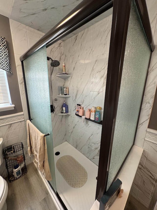 162 Pigeon Roost Rd, Brush Creek, TN 38547 - full bath with tile walls, a shower stall, toilet, a wainscoted wall, and wood finished floors