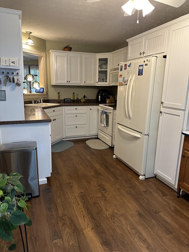 434 Hickman Shores Rd, Dover, TN 37058 - kitchen with white appliances, dark wood-style floors, white cabinetry, and a textured ceiling