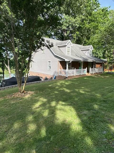 434 Hickman Shores Rd, Dover, TN 37058 - view of property exterior with covered porch and a lawn