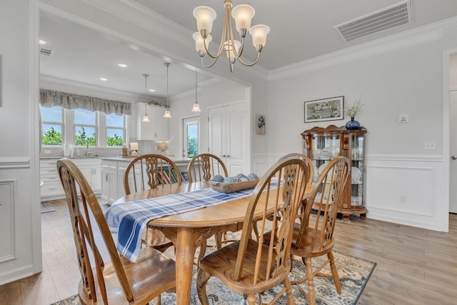 1514 Bledsoe Knl, Spring Hill, TN 37174 - dining area with crown molding, a chandelier, a decorative wall, wainscoting, and light wood finished floors