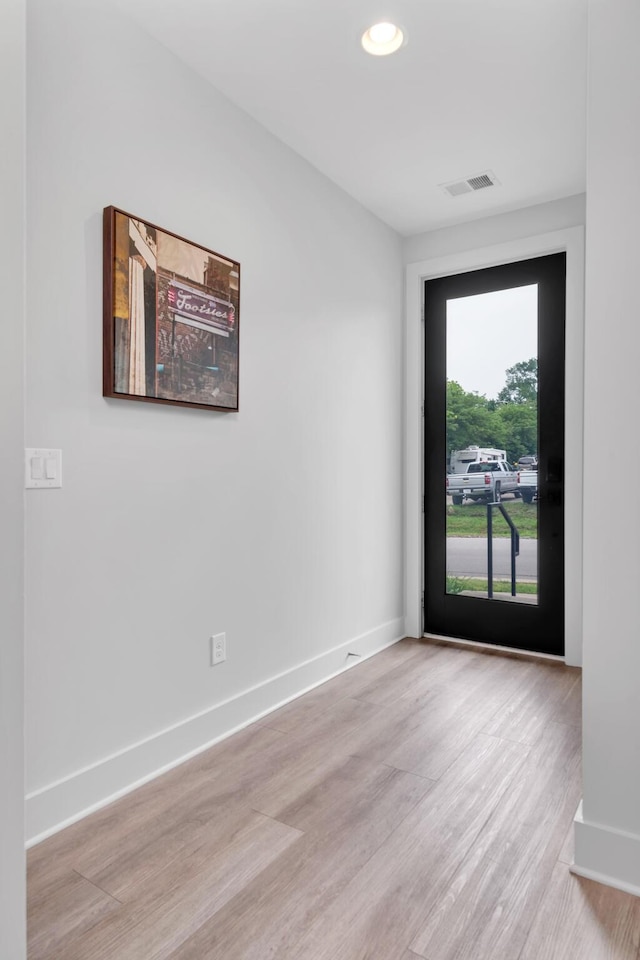 empty room featuring light wood-type flooring, baseboards, and recessed lighting