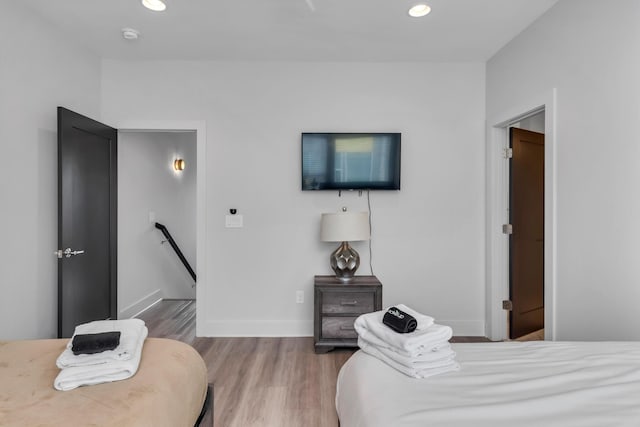 bedroom with wood finished floors, recessed lighting, and baseboards