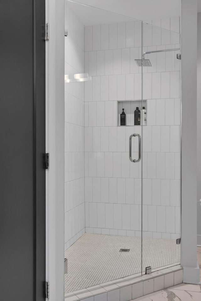 full bath featuring a stall shower and marble look tiles