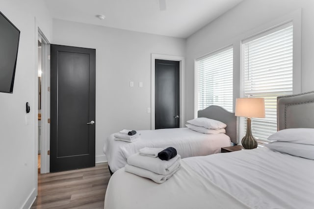 bedroom with wood finished floors, baseboards, and ceiling fan