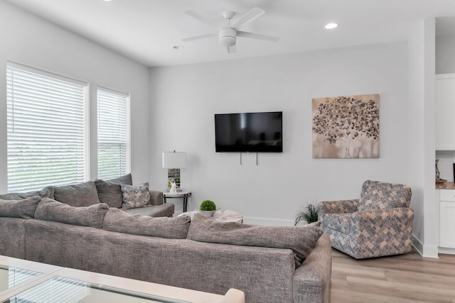 living room featuring light wood-type flooring, a ceiling fan, and recessed lighting