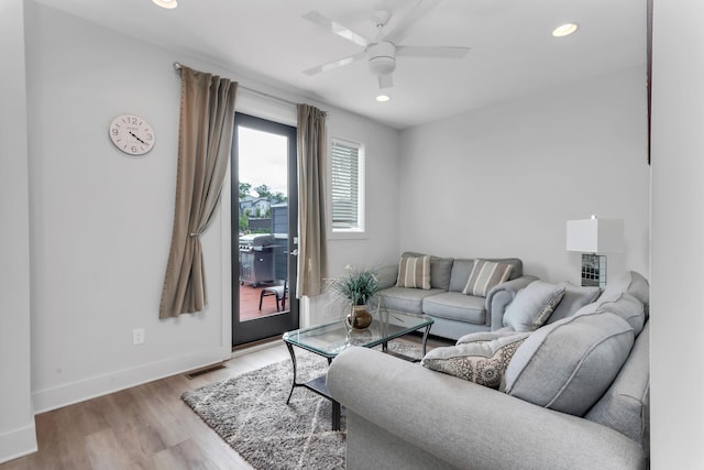 living area with light wood-style floors, baseboards, a ceiling fan, and recessed lighting