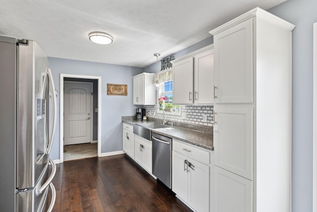 1014 Gill Hodges Rd, Portland, TN 37148 - kitchen with stainless steel appliances, a sink, tasteful backsplash, dark wood-style floors, and white cabinets
