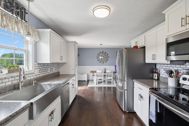 1014 Gill Hodges Rd, Portland, TN 37148 - kitchen featuring stainless steel appliances, a sink, white cabinets, decorative light fixtures, and tasteful backsplash
