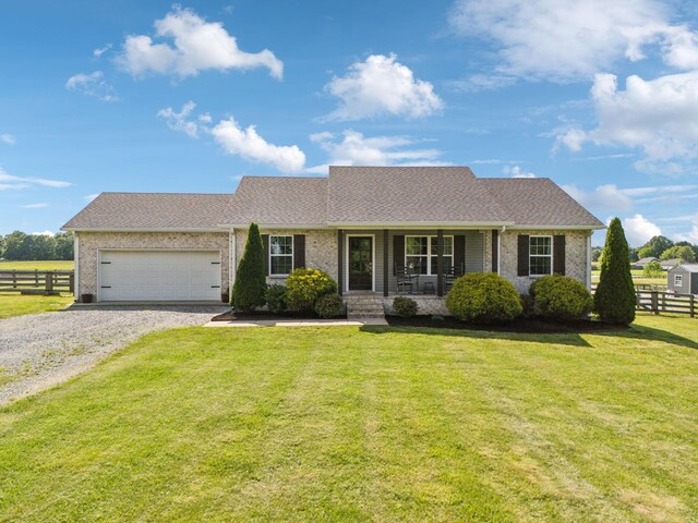 1014 Gill Hodges Rd, Portland, TN 37148 - view of front facade with brick siding, a garage, gravel driveway, covered porch, and a shingled roof