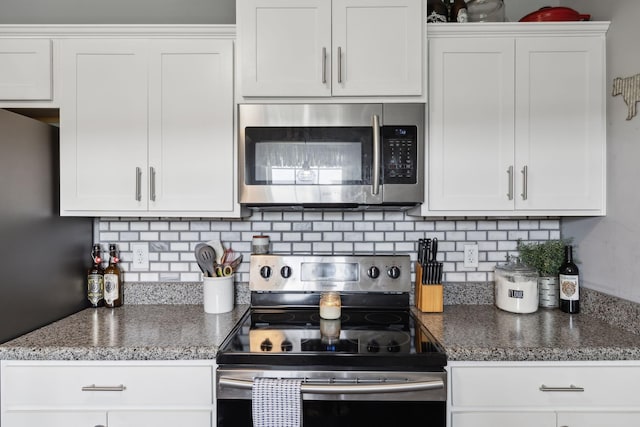 1014 Gill Hodges Rd, Portland, TN 37148 - kitchen featuring appliances with stainless steel finishes, white cabinets, tasteful backsplash, and dark stone counters