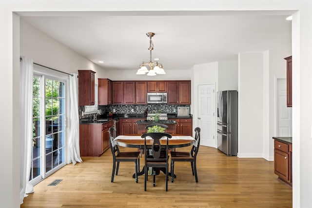 1201 Banbury Row, Brentwood, TN 37027 - kitchen featuring stainless steel appliances, dark countertops, a chandelier, a sink, and tasteful backsplash