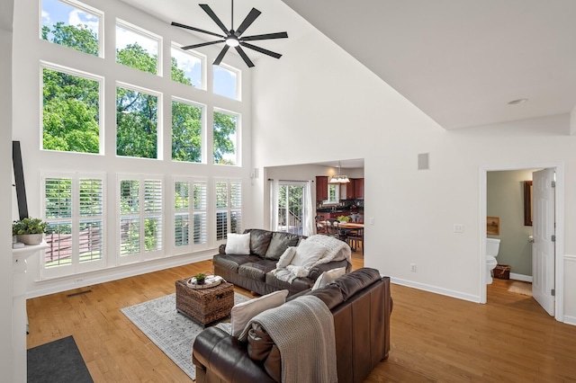 1201 Banbury Row, Brentwood, TN 37027 - living room with a high ceiling, a ceiling fan, light wood-style floors, and baseboards