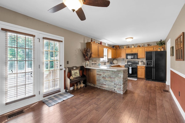 1325 Branchside Ct, Thompsons Station, TN 37179 - kitchen with black appliances, a peninsula, light countertops, dark wood-style flooring, and baseboards