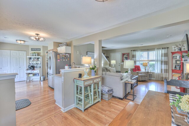 1753 Stone Hollow Ct, Hermitage, TN 37076 - living area with light wood-style floors, a textured ceiling, and a chandelier