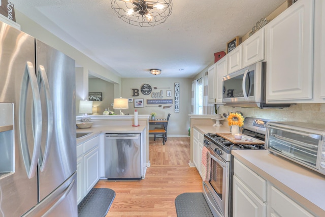1753 Stone Hollow Ct, Hermitage, TN 37076 - kitchen with appliances with stainless steel finishes, light wood finished floors, light countertops, white cabinetry, and backsplash