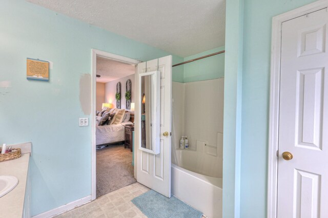 1753 Stone Hollow Ct, Hermitage, TN 37076 - bathroom featuring a textured ceiling, vanity,  shower combination, and connected bathroom