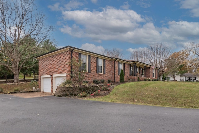 111 Proffitt St, Carthage, TN 37030 - view of front of house with brick siding, an attached garage, asphalt driveway, and a front lawn