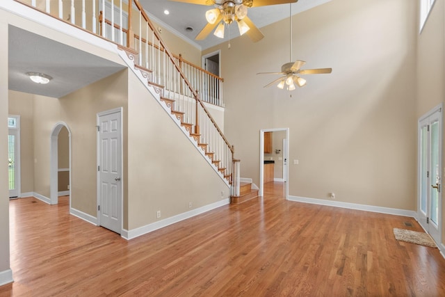 134 Blackberry Ln, Murfreesboro, TN 37130 - unfurnished living room with a ceiling fan, a towering ceiling, baseboards, wood finished floors, and stairway