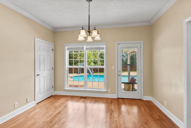 134 Blackberry Ln, Murfreesboro, TN 37130 - unfurnished dining area with a textured ceiling, a chandelier, crown molding, light wood-style floors, and baseboards