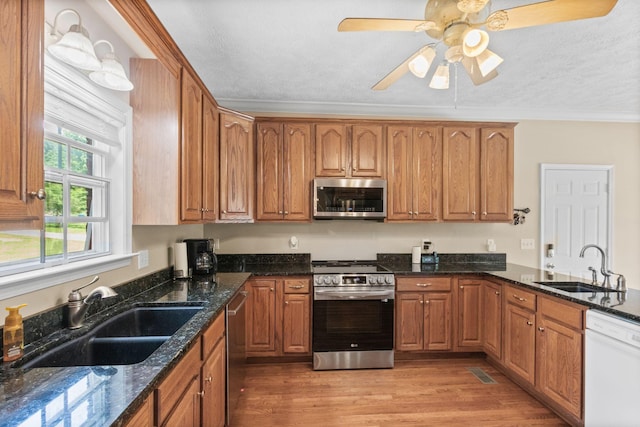 134 Blackberry Ln, Murfreesboro, TN 37130 - kitchen featuring appliances with stainless steel finishes, a sink, ornamental molding, brown cabinetry, and a textured ceiling