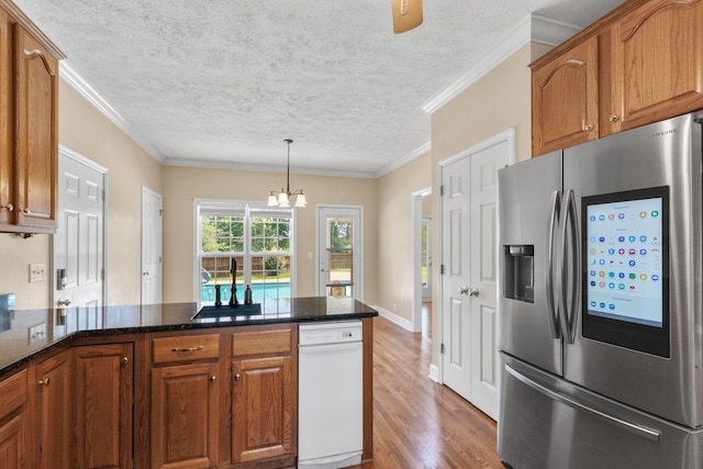 134 Blackberry Ln, Murfreesboro, TN 37130 - kitchen with stainless steel fridge, wood finished floors, a chandelier, brown cabinetry, and a textured ceiling