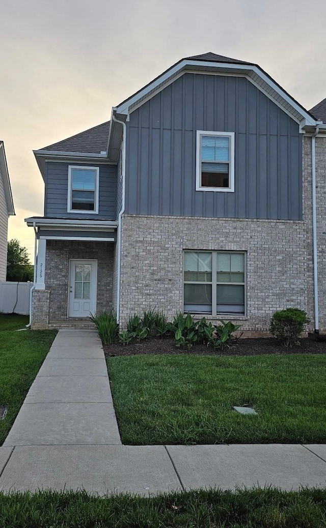 2126 Hospitality Ln, Murfreesboro, TN 37128 - view of front facade with board and batten siding, brick siding, and a front lawn