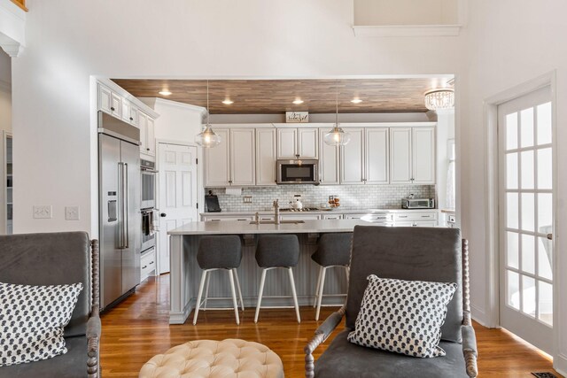 1505 Charleston Park Dr, Spring Hill, TN 37174 - kitchen with stainless steel appliances, decorative backsplash, wood finished floors, a sink, and an island with sink