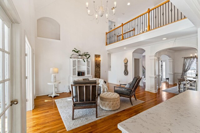 1505 Charleston Park Dr, Spring Hill, TN 37174 - living area with ornate columns, arched walkways, a high ceiling, plenty of natural light, and light wood-style floors