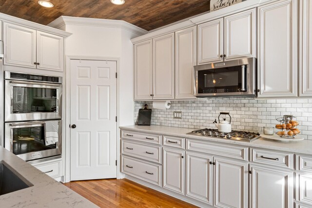 1505 Charleston Park Dr, Spring Hill, TN 37174 - kitchen featuring wood ceiling, appliances with stainless steel finishes, light wood-type flooring, backsplash, and white cabinets