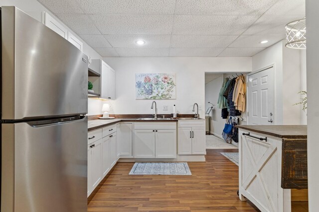 1505 Charleston Park Dr, Spring Hill, TN 37174 - kitchen featuring freestanding refrigerator, a sink, a drop ceiling, white cabinetry, and wood finished floors