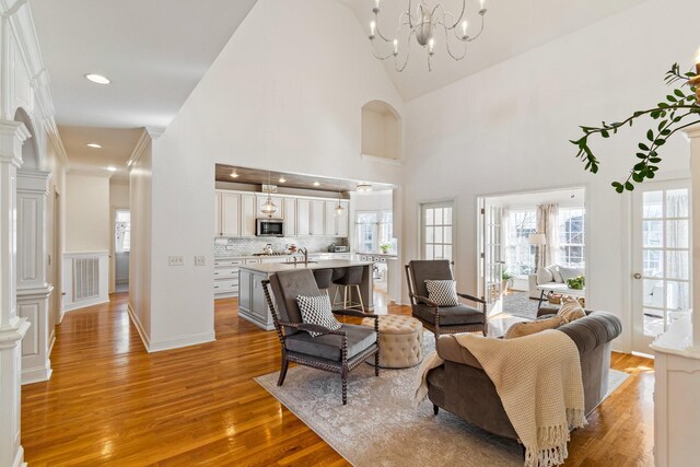 1505 Charleston Park Dr, Spring Hill, TN 37174 - living room featuring light wood-style floors, decorative columns, high vaulted ceiling, a chandelier, and recessed lighting