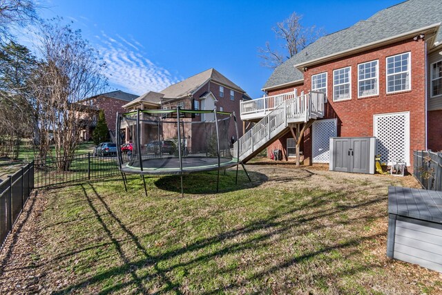 1505 Charleston Park Dr, Spring Hill, TN 37174 - rear view of house featuring a trampoline, stairway, brick siding, and a wooden deck