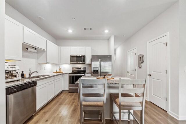 105 Grayson Cir, Chapel Hill, TN 37034 - kitchen with stainless steel appliances, a sink, light wood-style floors, white cabinets, and backsplash