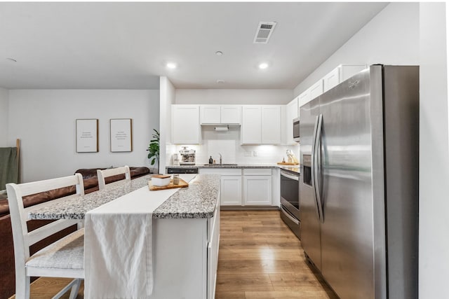 105 Grayson Cir, Chapel Hill, TN 37034 - kitchen with stainless steel appliances, a sink, white cabinets, a breakfast bar area, and a kitchen island