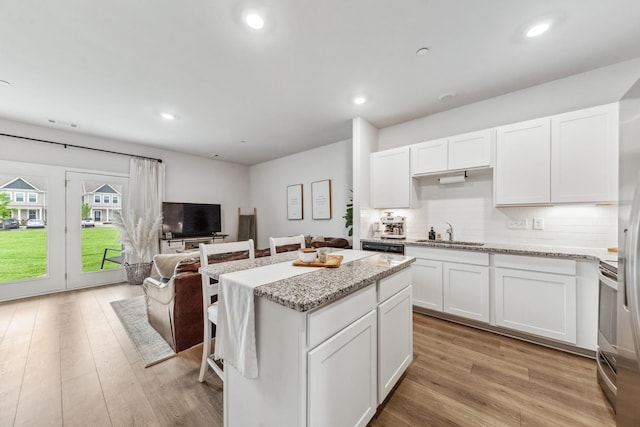 105 Grayson Cir, Chapel Hill, TN 37034 - kitchen featuring a sink, backsplash, a kitchen island, light stone countertops, and white cabinets