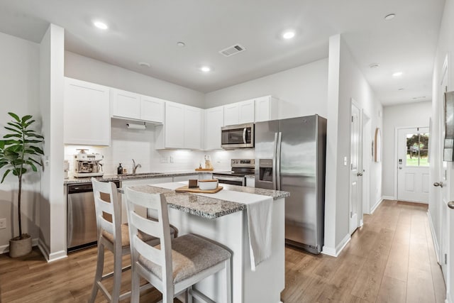 105 Grayson Cir, Chapel Hill, TN 37034 - kitchen featuring stainless steel appliances, light wood-type flooring, white cabinetry, tasteful backsplash, and light stone counters