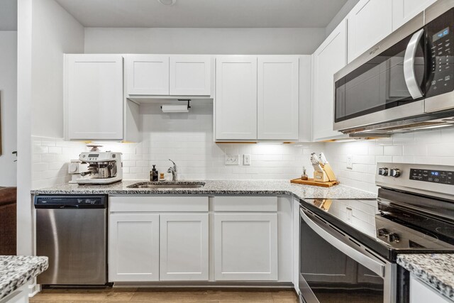 105 Grayson Cir, Chapel Hill, TN 37034 - kitchen featuring stainless steel appliances, white cabinets, a sink, tasteful backsplash, and light stone countertops
