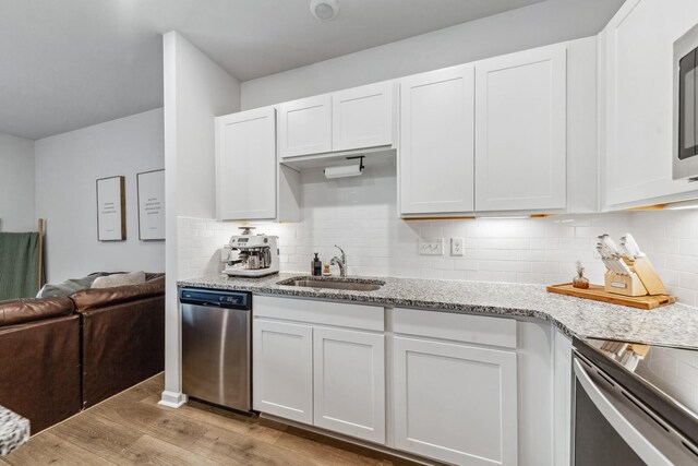105 Grayson Cir, Chapel Hill, TN 37034 - kitchen featuring appliances with stainless steel finishes, light wood-style floors, white cabinets, light stone countertops, and a sink