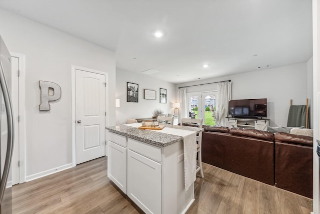 105 Grayson Cir, Chapel Hill, TN 37034 - kitchen featuring white cabinetry, light wood-style floors, light stone countertops, a kitchen island, and recessed lighting