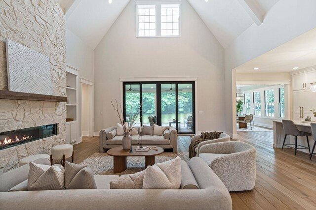 4617 Delta Springs Ln, Franklin, TN 37064 - living room featuring high vaulted ceiling, light wood-style flooring, built in features, baseboards, and a fireplace