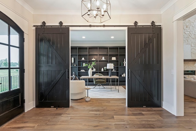 4617 Delta Springs Ln, Franklin, TN 37064 - entrance foyer featuring a barn door, crown molding, wood finished floors, and a chandelier