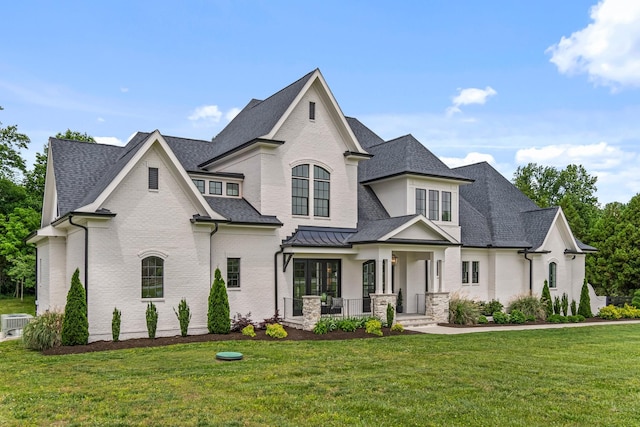 4617 Delta Springs Ln, Franklin, TN 37064 - french provincial home featuring covered porch, a front lawn, a shingled roof, cooling unit, and a standing seam roof