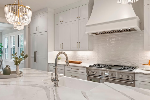4617 Delta Springs Ln, Franklin, TN 37064 - kitchen with custom range hood, double oven range, a chandelier, and backsplash