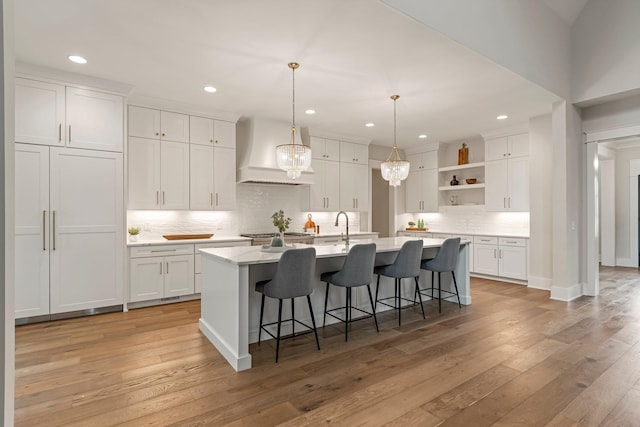 4617 Delta Springs Ln, Franklin, TN 37064 - kitchen with custom range hood, open shelves, white cabinetry, backsplash, and light wood-type flooring