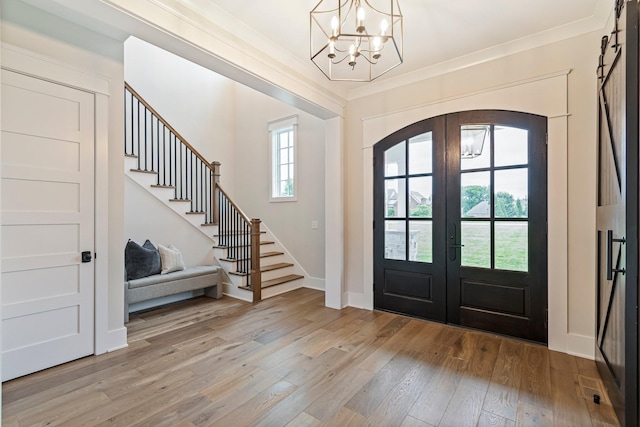4617 Delta Springs Ln, Franklin, TN 37064 - foyer entrance featuring french doors, stairs, arched walkways, light wood-style floors, and a chandelier