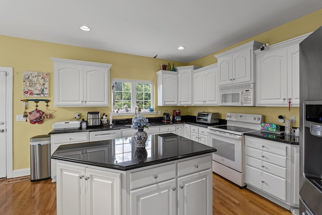 6769 Cold Stream Dr, Nashville, TN 37221 - kitchen featuring white appliances, white cabinets, dark countertops, light wood-type flooring, and recessed lighting