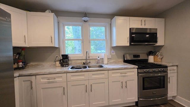 500 E 17th St, Columbia, TN 38401 - kitchen with appliances with stainless steel finishes, a sink, white cabinets, and dark wood-style floors