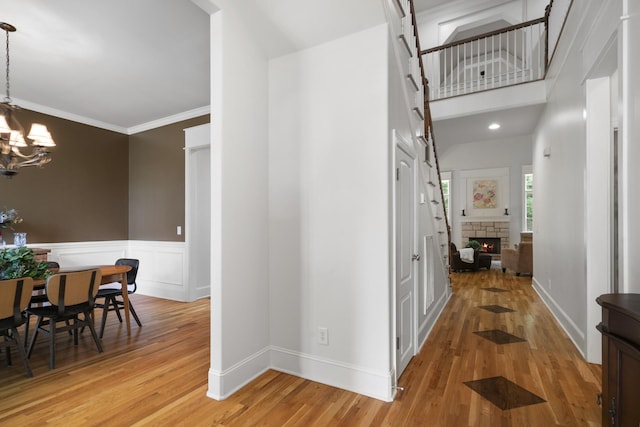 4019 Fremantle Cir, Spring Hill, TN 37174 - hallway featuring a chandelier, light wood-style floors, ornamental molding, a wainscoted wall, and baseboards